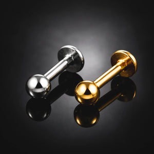 Três piercings labret de titânio G23 com bolinha sobre fundo preto -destaque do topo e da haste