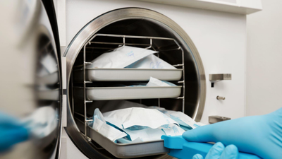 A imagem mostra o processo de esterilização de materiais médicos ou odontológicos.