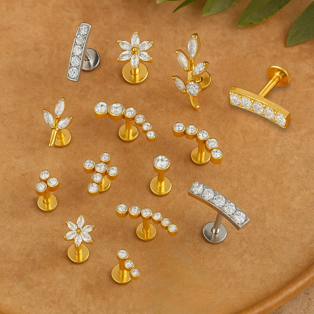 Piercing labret com design profissional em exposição, modelo com pedra de zircônia, prata e dourado, em variados tamanhos.