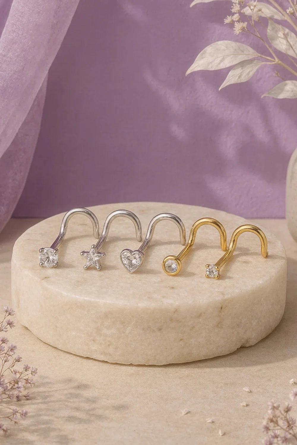 Piercing nostril em titânio G23, exposto sobre pedra. Versões em prata e dourado com pedras de zircônia em diferentes tamanhos.