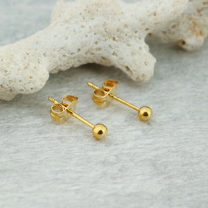 Par de brincos metálicos de aço cirúrgico cor dourada formato bolinha com estrela do mar decorativa