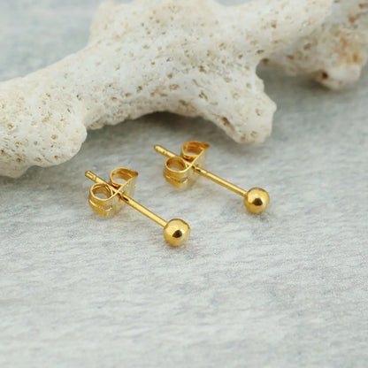 Par de brincos metálicos de aço cirúrgico cor dourada formato bolinha com estrela do mar decorativa