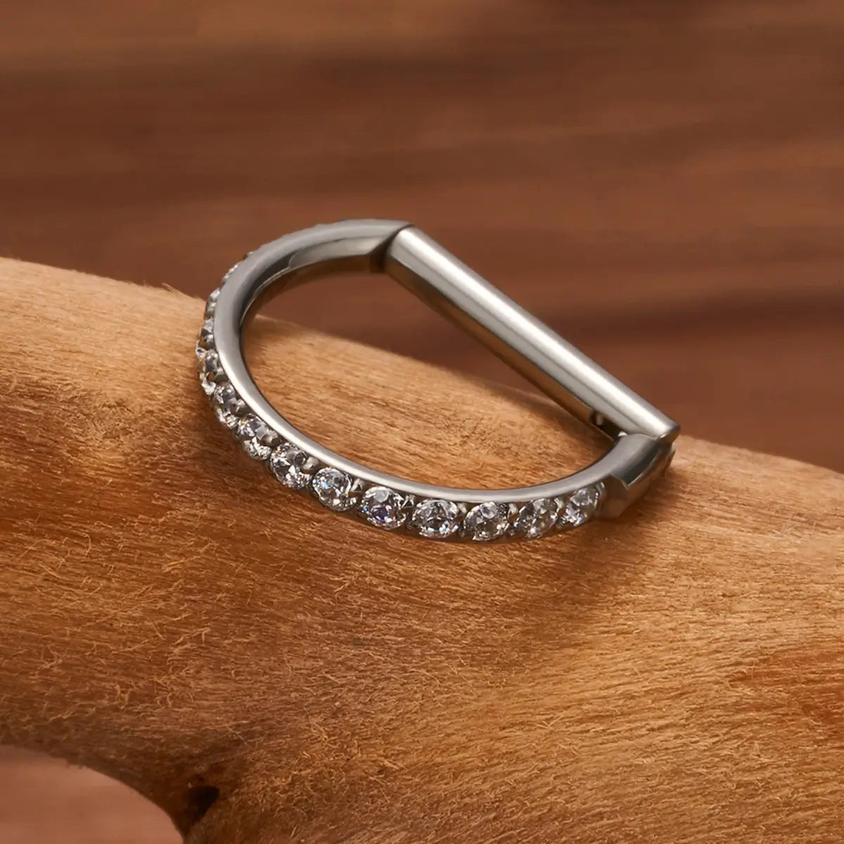 Piercing argola reta de titânio prateada com zircônias em uso na orelha
