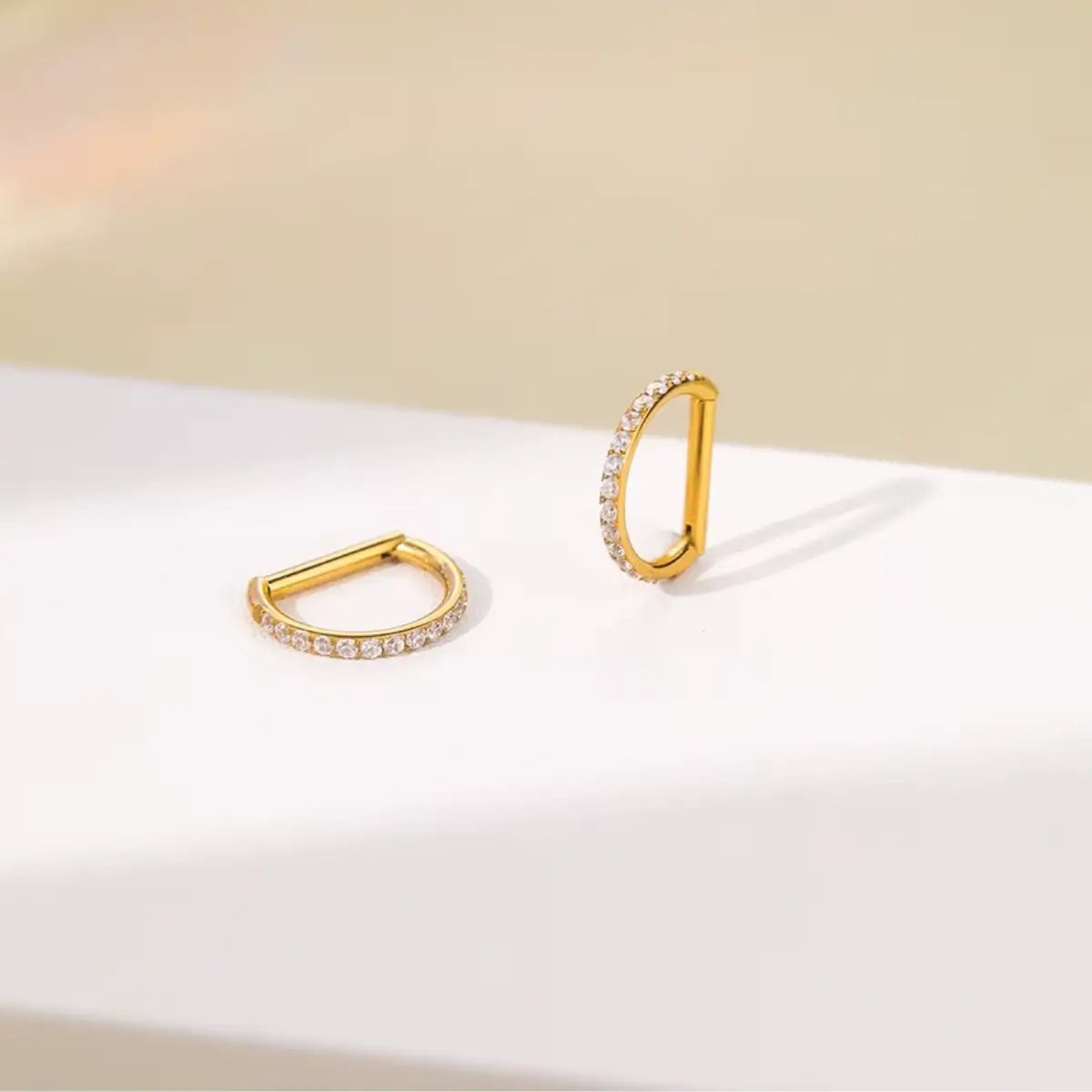Par de piercings argola reta de titânio dourada com zircônias cravadas