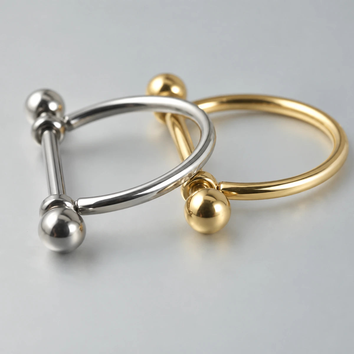 Piercing barbell com arco liso em acabamento prateado e dourado