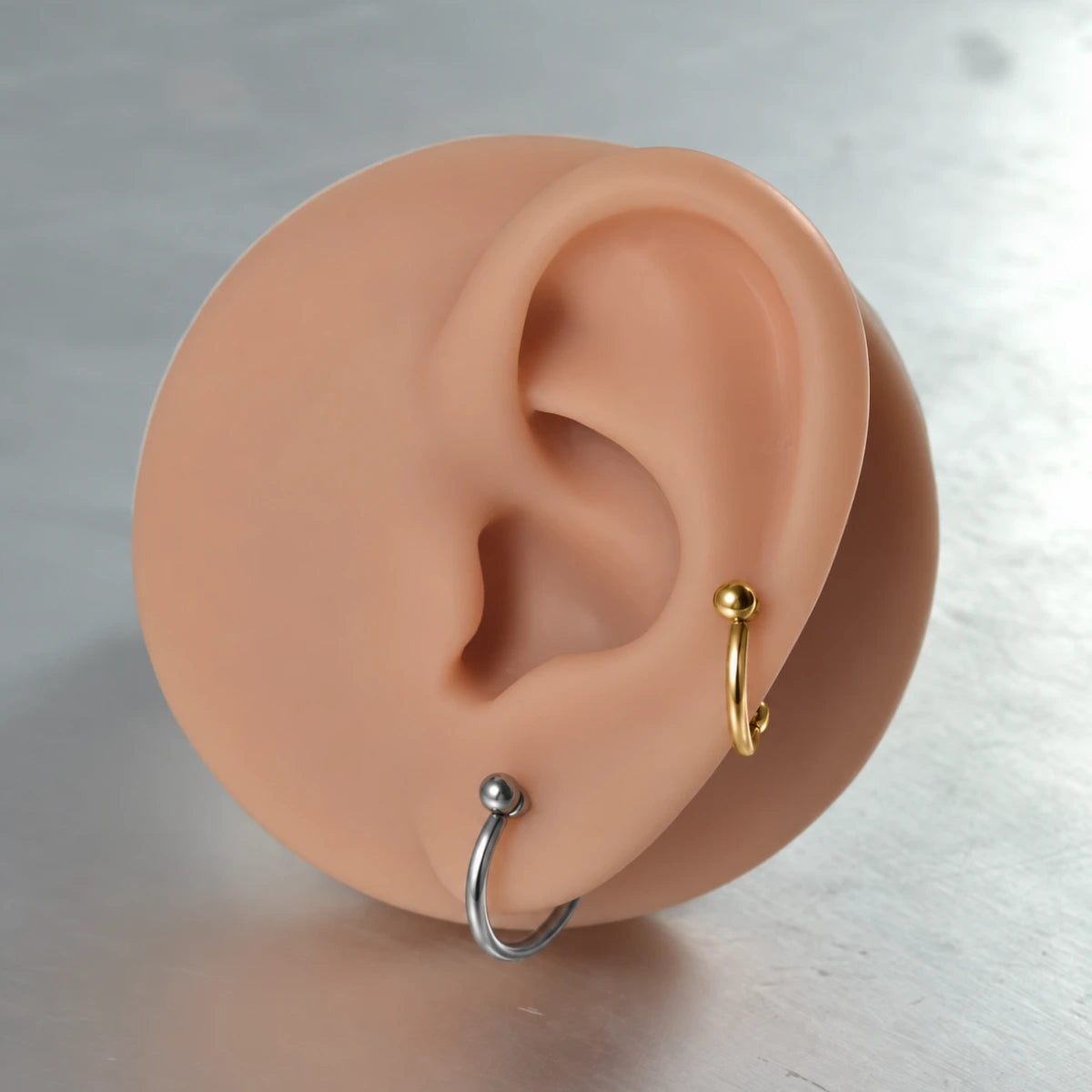 Piercing com arco liso aplicado em composição de orelha