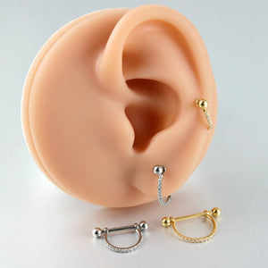 Piercing com arco de zircônias aplicado em composição de orelha