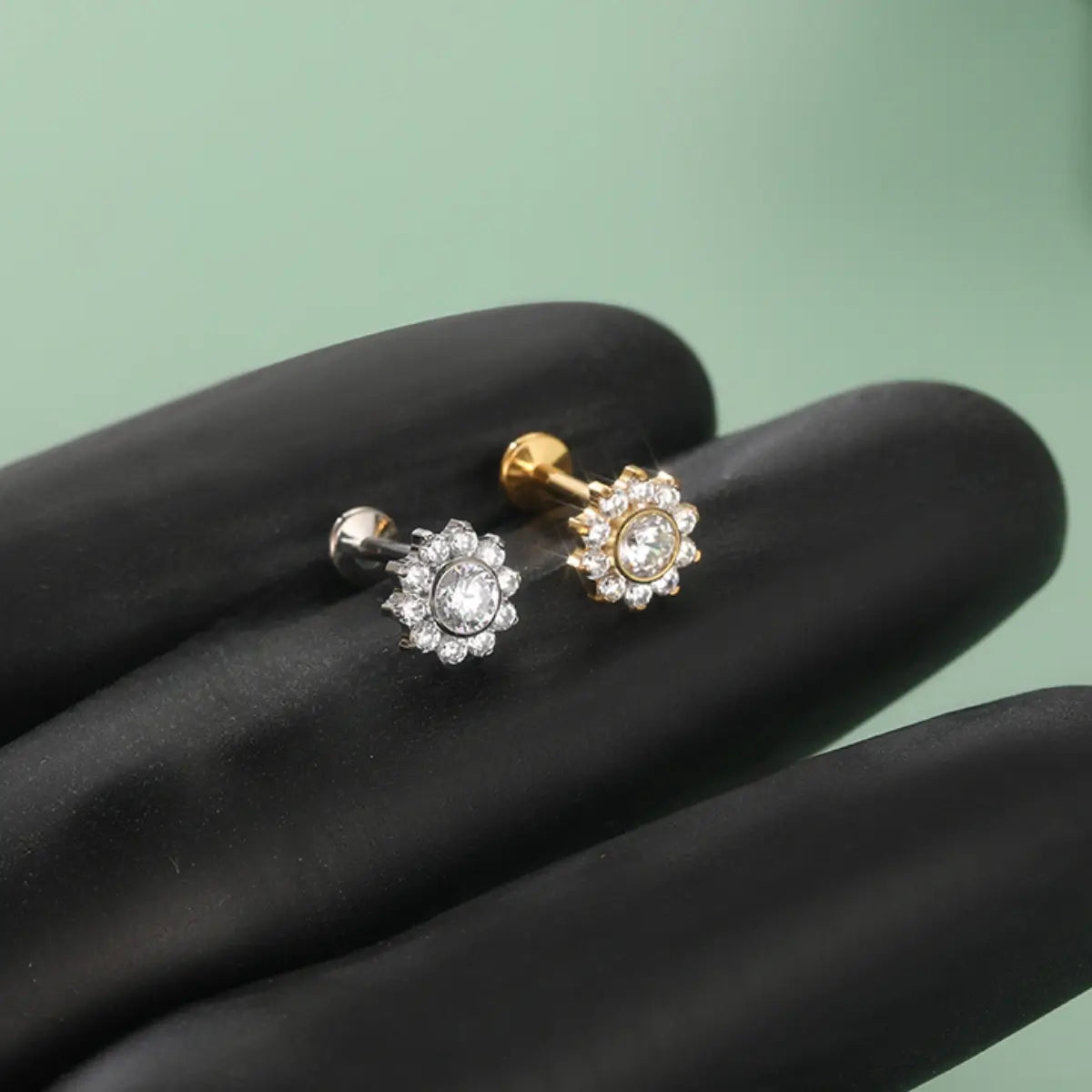 Piercings labret de titânio circular formato flor com zircônias sobre fundo escuro