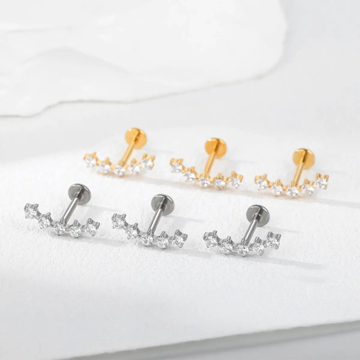 Conjunto de piercings labret de titânio com cluster espaçado de 5 zircônias nas versões prata e dourado