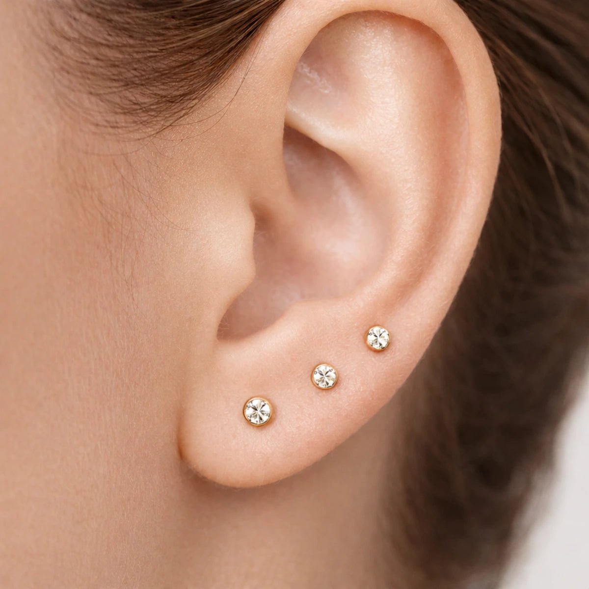 Piercing labret ponto de luz aplicado no lóbulo em composição delicada de orelha
