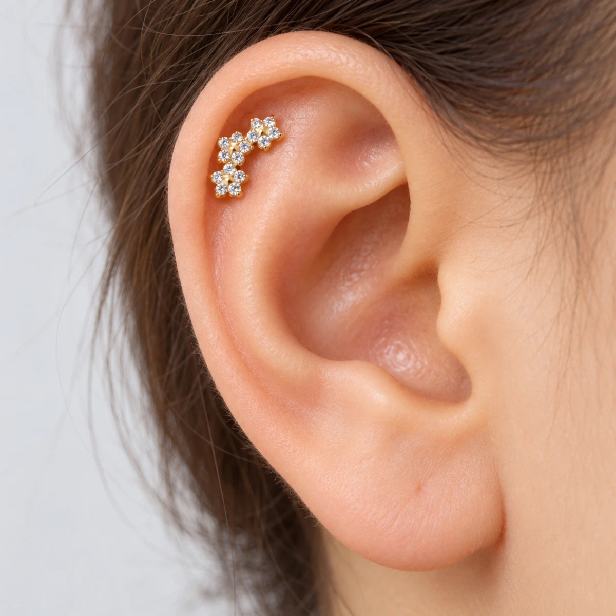 Piercing floral com trio de flores aplicado na orelha