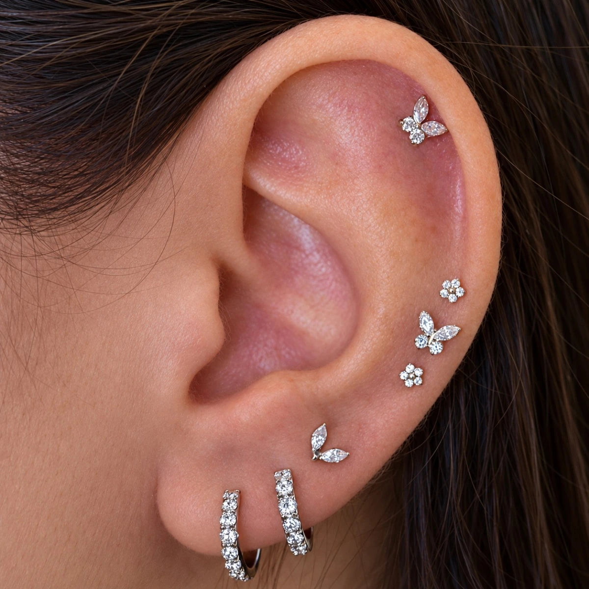Piercing Mini Borboleta Push Pin prateado aplicado na orelha